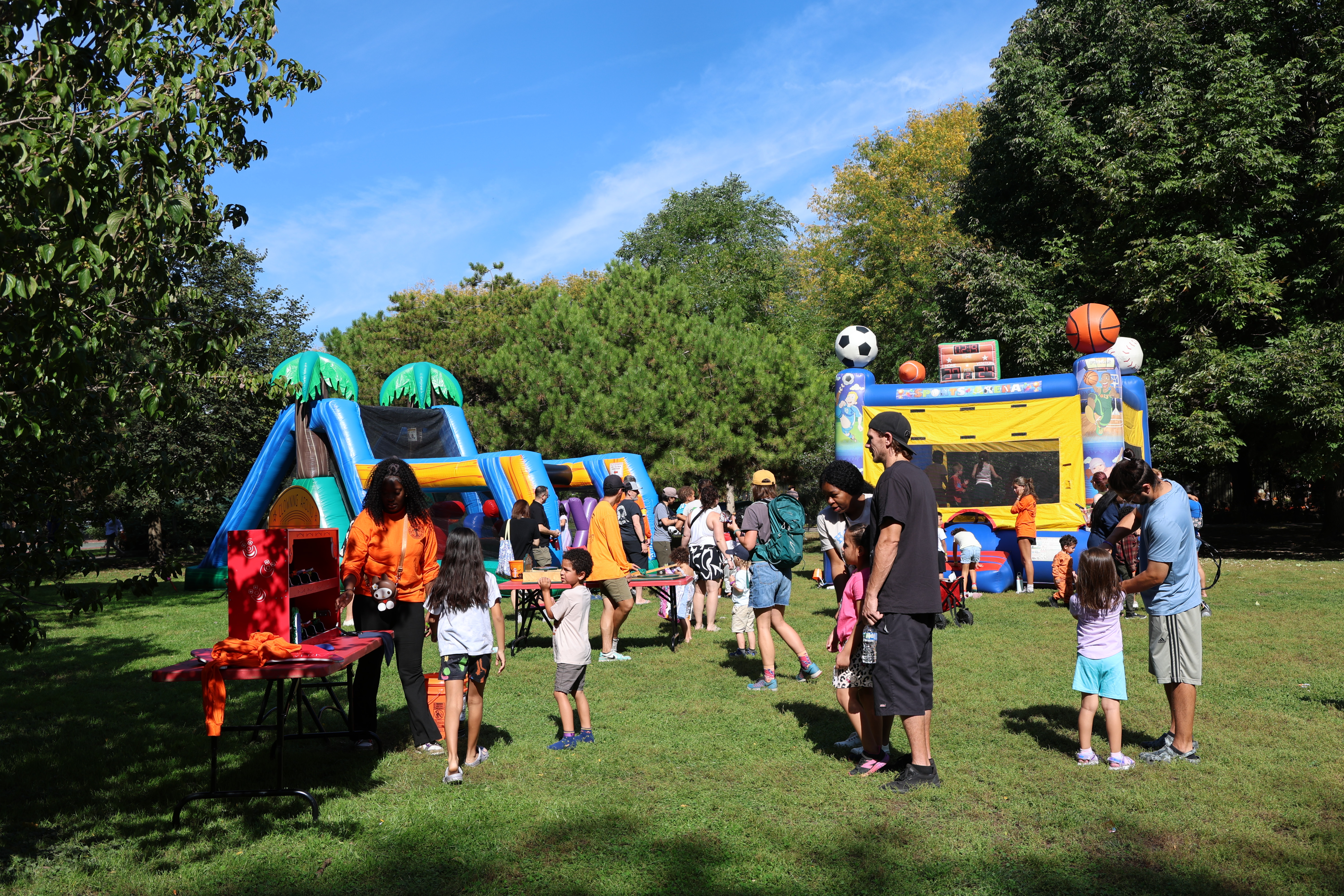 Outdoor festival with inflatables on sunny day.